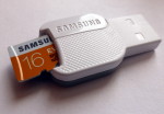 Photo d'un mini adaptateur micro SD vers USB. Une carte de 16 Go dépasse du lecteur de carte micro SD